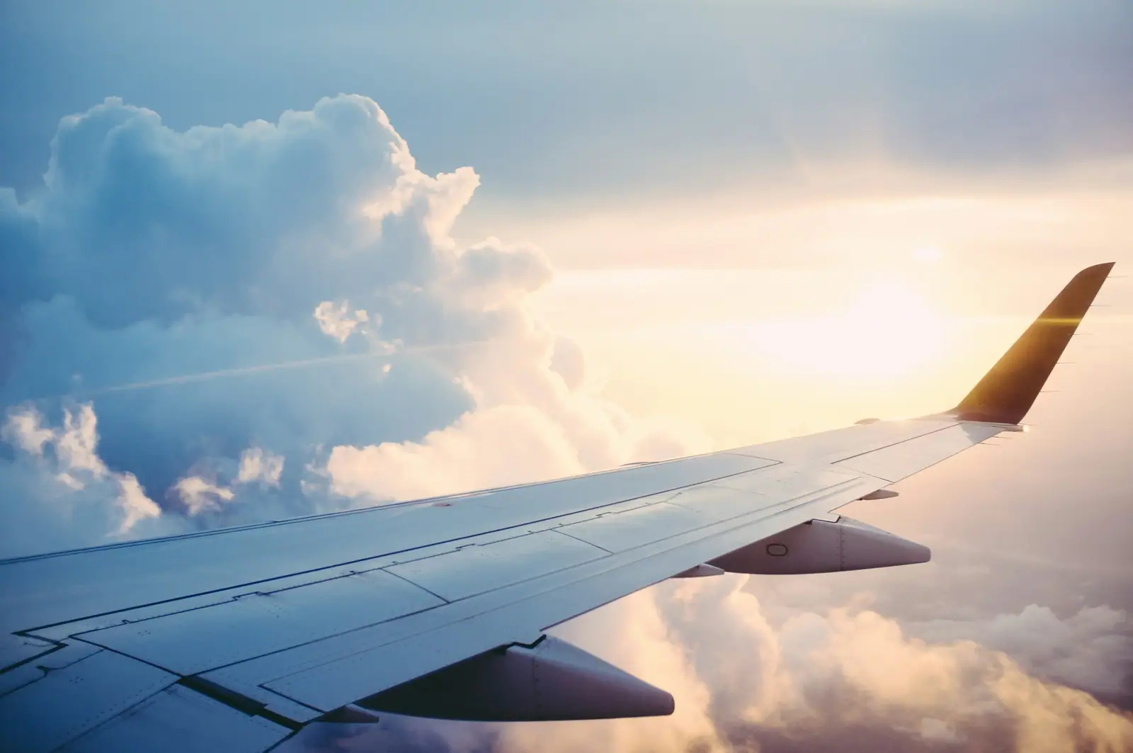 Flugzeugflügel über den Wolken im Abendlicht