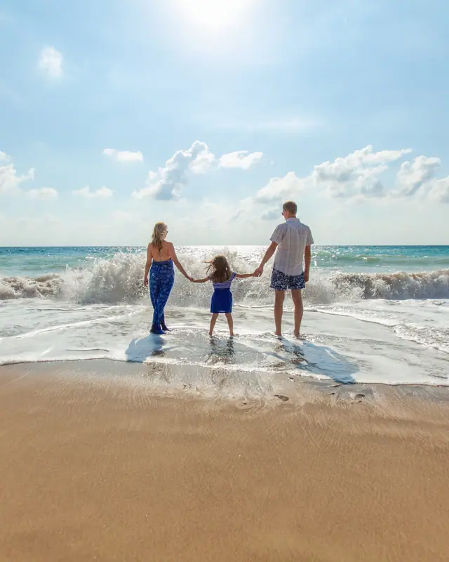 Familie am Strand im türkisen Meer